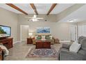 Cozy living room with beamed ceiling, neutral paint, and tile flooring at 5828 Lincoln Rd, Venice, FL 34293