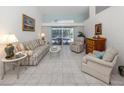 Bright living room with neutral tones, tile flooring, and sliding glass doors leading to the pool area at 609 Madrid Ave, Venice, FL 34285