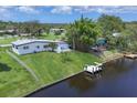 Waterfront home featuring a canal view, private dock, and lush backyard on a sunny, cloud filled day at 6821 Marius Rd, North Port, FL 34287