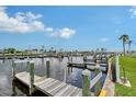 Waterfront community dock featuring boat slips and wooden piers along a canal with a scenic sky at 738 Riverview Cir, North Port, FL 34287