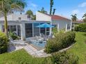 Charming patio area with a blue umbrella, table and chairs, plus a chaise lounge for outdoor relaxation at 751 Capri Isles Blvd # 108, Venice, FL 34292