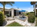Lovely outdoor patio featuring a table, chairs, blue umbrella, and a chaise lounge for relaxing and entertaining at 751 Capri Isles Blvd # 108, Venice, FL 34292
