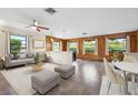 Bright living room with wood paneled accent wall, updated ceiling fan, and views of the surrounding landscape at 844 Senda Plata # 27, Venice, FL 34293