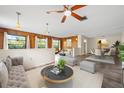 Bright living room with wood paneled accent wall, updated ceiling fan, and views of the surrounding landscape at 844 Senda Plata # 27, Venice, FL 34293