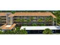 Three-story condo building with tan exterior, balconies, and lush tropical landscaping at 849 Wexford Blvd # 849, Venice, FL 34293