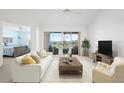 Bright living room featuring sliding glass doors to a balcony overlooking a golf course at 849 Wexford Blvd # 849, Venice, FL 34293