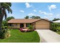 Well-maintained single-story home with lush landscaping and a long driveway at 925 S Doral Ln, Venice, FL 34293