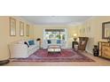 Bright living room featuring neutral walls, comfortable seating, and large area rug at 925 S Doral Ln, Venice, FL 34293