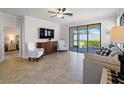 Inviting living room with a view of the screened-in patio through the sliding glass door at 9917 Haze Dr, Venice, FL 34292