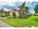 Beautiful single-story home showcasing lush landscaping, a paver driveway, and a well-maintained lawn at 10061 Cozy Grove Dr, Venice, FL 34293