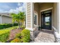 Inviting front porch featuring stone pillars, a black front door, and well-maintained landscaping at 11240 Spring Gate Trl, Bradenton, FL 34211