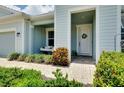 Close up of home entrance featuring hanging swing, brick walkway and decorative door wreath at 11560 Tapestry Ln, Venice, FL 34293