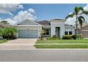 Inviting single-story home featuring lush landscaping, paver driveway, and charming curb appeal at 11560 Tapestry Ln, Venice, FL 34293