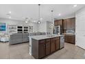 Open kitchen features a spacious island, stainless steel appliances, and seating at 11970 Lovegrass St, Venice, FL 34293