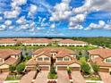 Stunning aerial of townhomes near a scenic lake, showcasing beautiful landscaping and design at 12590 Ghiberti Cir # 201, Venice, FL 34293