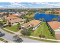 Expansive lakefront community featuring homes with tile roofs, lush greenery, and a charming bridge at 13334 Pacchio St, Venice, FL 34293