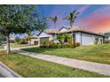 Well-maintained single-story home with lush landscaping, tile roof, and a neatly paved walkway at 13334 Pacchio St, Venice, FL 34293
