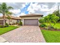 Lovely home with a brick driveway, meticulously manicured lawn and lush landscaping at 13913 Alafaya St, Venice, FL 34293