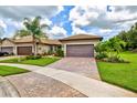 Beautiful home with a brick driveway and a well-manicured lawn and landscape at 13913 Alafaya St, Venice, FL 34293