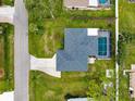 Aerial view of home with dark roof, screened-in pool, driveway, and landscaped surroundings at 1536 Porpoise Rd, Venice, FL 34293