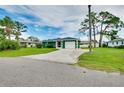 Single-story home with well-kept lawn, paved driveway, and lush green exterior for a comfortable feel at 1536 Porpoise Rd, Venice, FL 34293