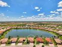 Expansive aerial view showcasing community homes surrounding a large lake with subject property highlighted at 20370 Grazie Pl, Venice, FL 34293