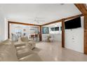 Spacious living area featuring an open layout, white floors, neutral paint, and natural wood beams at 2185 Park Rd, Venice, FL 34293