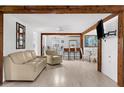 Open-concept living room with exposed wood beams, white walls, and light wood floors at 2185 Park Rd, Venice, FL 34293