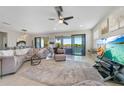Bright living room features a large sectional, ceiling fan, access to a balcony and stunning water view at 23527 Awabuki # 202, Venice, FL 34293