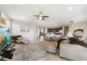 Expansive living room with tile floors, comfortable seating, modern decor, and seamless flow to dining area at 23527 Awabuki # 202, Venice, FL 34293