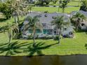 Aerial view of the backyard with a screened-in pool, lush tropical landscaping and a waterfront view at 24339 Matias Ln, Punta Gorda, FL 33955