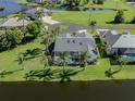Aerial view of the backyard with a screened-in pool, waterfront view and lush tropical landscaping at 24339 Matias Ln, Punta Gorda, FL 33955