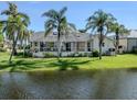 Home exterior showcasing a screened in lanai, waterfront view, and tropical landscaping in the backyard at 24339 Matias Ln, Punta Gorda, FL 33955