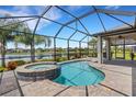 Relaxing screened-in pool with an attached jacuzzi overlooking the pond at 2487 Marton Oak Blvd, North Port, FL 34289