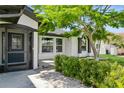 Beautiful front entrance with a decorative glass door and covered porch, surrounded by lush landscaping at 26115 Rampart Blvd, Punta Gorda, FL 33983