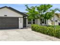 Attractive home featuring a two-car garage, mature landscaping, and a well-manicured lawn at 26115 Rampart Blvd, Punta Gorda, FL 33983