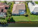 Aerial view of the property's backyard, with a pool, landscaping, and serene lake views at 2928 Seasons Blvd, Sarasota, FL 34240