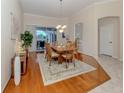 Inviting dining room with wood flooring, a stylish chandelier, and sliding glass doors to the lanai at 2928 Seasons Blvd, Sarasota, FL 34240