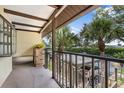 Balcony view with iron railing, outdoor plants, and views of the covered parking and community greenery at 330 Mission N Trl # B, Venice, FL 34285