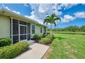 Exterior of a home with a screened lanai, well-maintained lawn, and serene pond view at 371 Capulet Dr, Venice, FL 34292