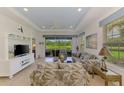Inviting living room with stylish coastal decor, tile floors, and serene lake views at 371 Capulet Dr, Venice, FL 34292