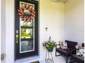 Front door adorned with wreath, with a cozy sitting area to the side at 4033 Union Ln, North Port, FL 34288