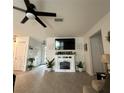 Spacious living room with stylish fireplace, ceiling fan and wood-look tile flooring at 4033 Union Ln, North Port, FL 34288
