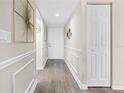Inviting hallway featuring wood flooring, wainscoting, and decorative wall art at 408 Cerromar S Cir # 331, Venice, FL 34293