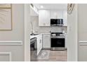 Modern kitchen view through doorway featuring stainless appliances and white cabinetry at 408 Cerromar S Cir # 331, Venice, FL 34293