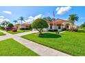 Inviting single-story home featuring a lush lawn and mature palm trees, showcasing curb appeal at 4114 Murfield E Dr, Bradenton, FL 34203