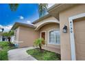 Exterior view of a well-maintained home with an arched entry, lush lawn, and a mature palm tree at 4150 Otoole St, North Port, FL 34291