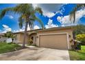 Inviting exterior featuring a two-car garage, well-maintained lawn, and mature landscaping under a sunny sky at 4150 Otoole St, North Port, FL 34291
