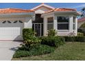 Charming single-story home featuring a red tile roof, well-manicured lawn, and an attached two-car garage at 4831 Summertree Rd, Venice, FL 34293