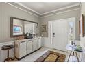 Inviting foyer with neutral paint, crown molding, tile flooring, and a decorative mirror at 511 Wexford Dr, Venice, FL 34293